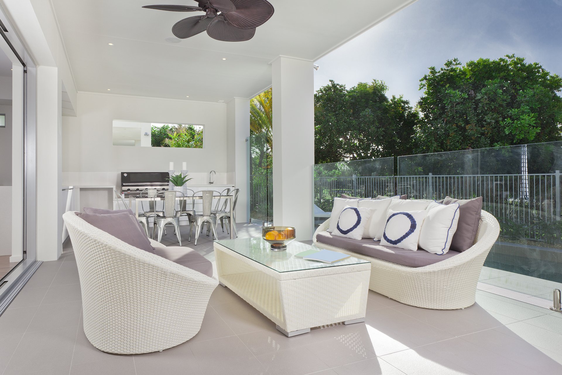 Luxurious undercover patio with couches, barbeque and dining area